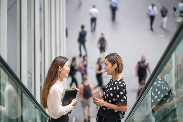 istock Two ladies on the escalator talking 905520588