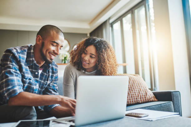 simplificar la administración financiera del hogar con tecnología moderna - laptop women sofa internet fotografías e imágenes de stock