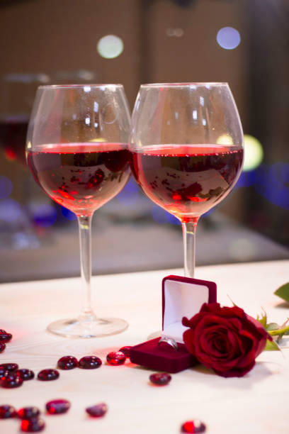 istock Two glasses of red wine with a red rose 905527578