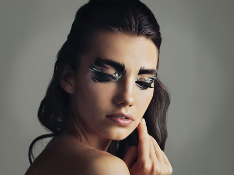 Studio shot of an attractive young woman wearing bold eye makeup