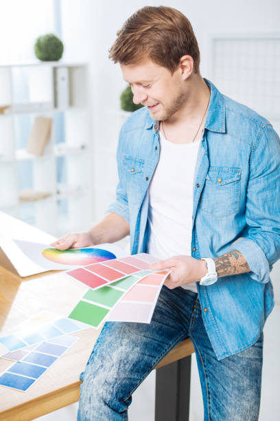 istock Young man sitting on the table and looking at color palettes 905531048
