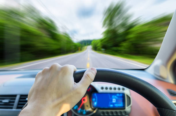 istock Single hand holding right steering wheel driving on motion road 905531290