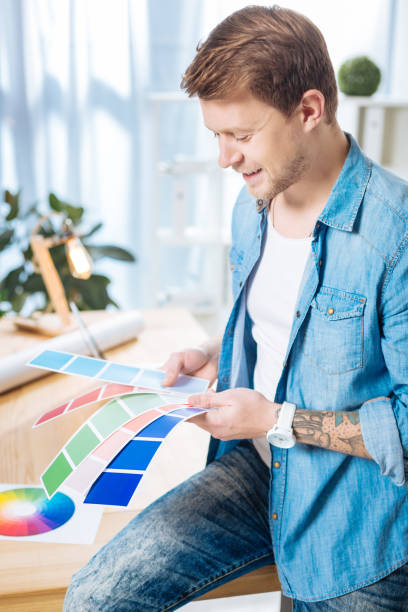 istock Experienced designer holding color palettes and smiling happily 905531512