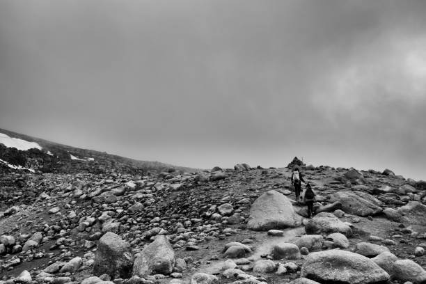 Two unrecognizable hikers in Icelandic Highlands, rear view, walking in volcanic rock formation, boulder, Kerlingarfjöll, black and white
