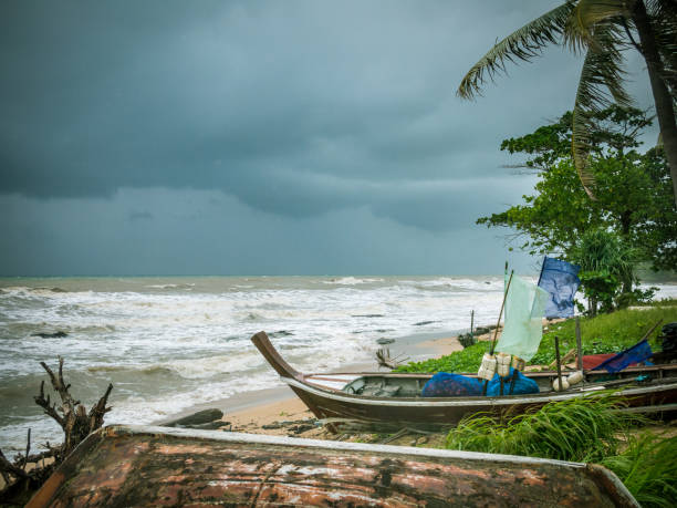 istock Longtail boats on the beach during tropical storm 905535992