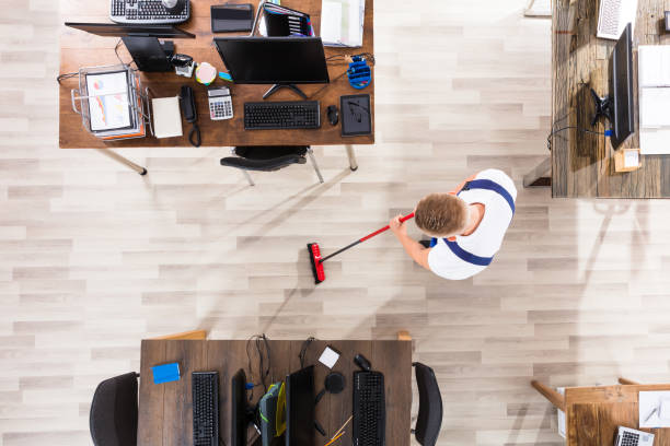 istock Janitor Cleaning Floor With Broom In Office 905536738