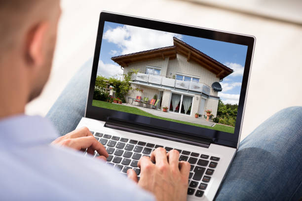 istock Man Looking At House Exterior On Laptop 905536928