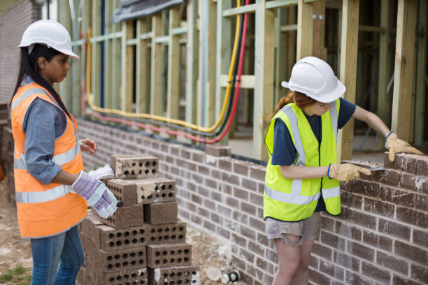 istock Building on construction site, woman brick layer and her assistant 905539990