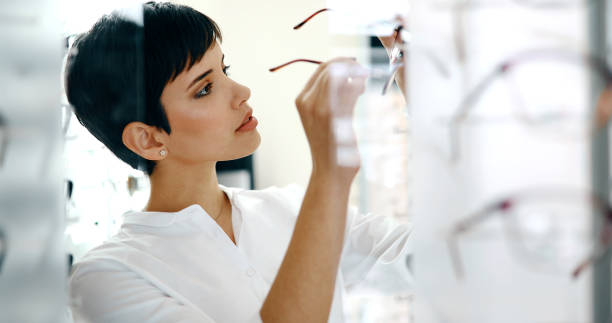 istock Beautiful woman with optician trying eyeglasses 905540270
