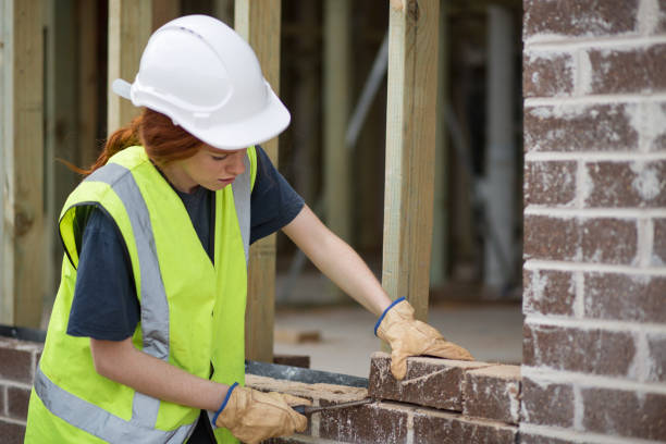 pedreiro de mulher preparando colocando tijolos na parede - brick construction construction site bricklayer - fotografias e filmes do acervo