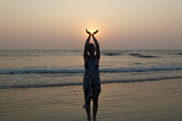 Girl and sun The beautiful girl holds the sun falling in the sea in palms religion sunbeam one person children only stock pictures, royalty-free photos & images