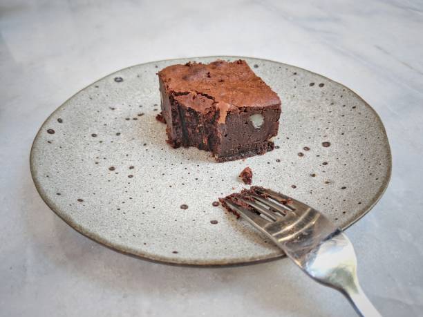 шоколадное пирожное и вилка на тарелке, уже съеденные или по вкусу. - brownie baked pastry crust chocolate стоковые фото и изображения