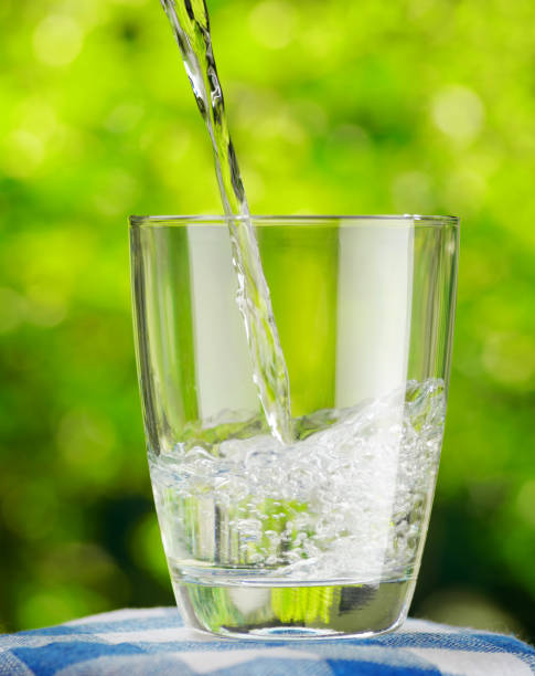 istock Glass of water on nature background 905545016