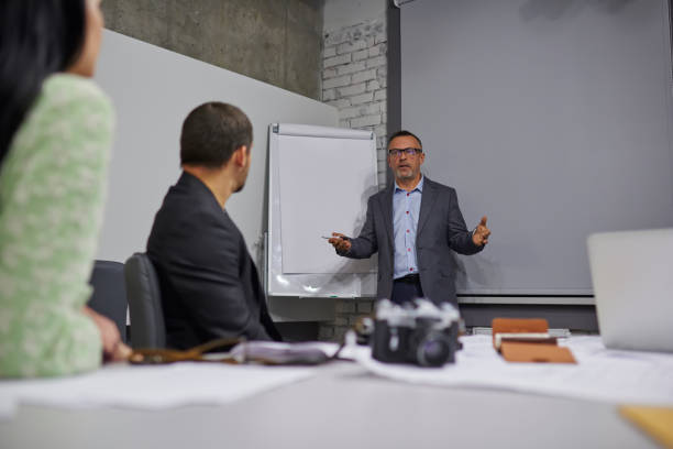istock Professional manure coach dressed in formal wear conducting productive business workshop for employees of finance company in stylish office building.Mock up area for your advertising text message 905553264