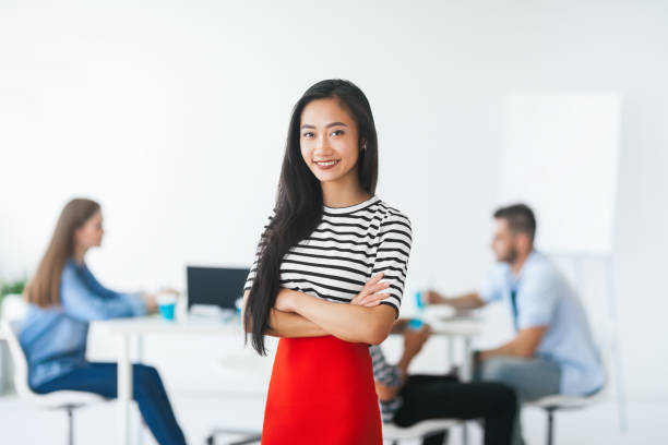 istock Confident asian leader with her team on background 905553962