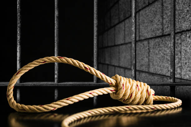 Brown rope noose dark and light on black table with old prison bars cell lock background dark black and light Brown rope noose dark and light on black table with old prison bars cell lock background dark black and light, concept of punishment hangman stock pictures, royalty-free photos & images