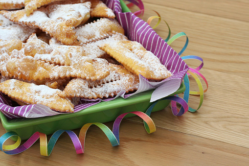 Italian carnival pastry on wooden background. Traditional Crostoli or chiacchere, bugie or cenci.
