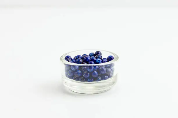 round blue with gold flecks jewelry beads in a small clear glass bowl on white