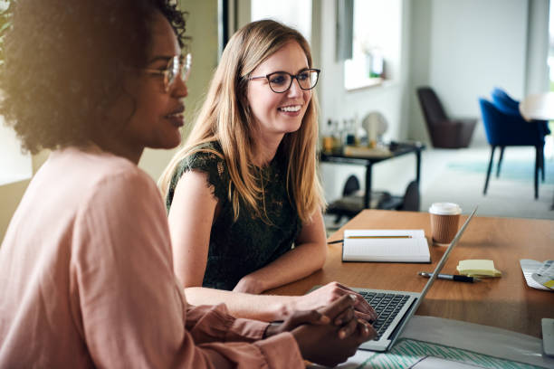 istock Smiling female designers working at a boardroom table together 905568592