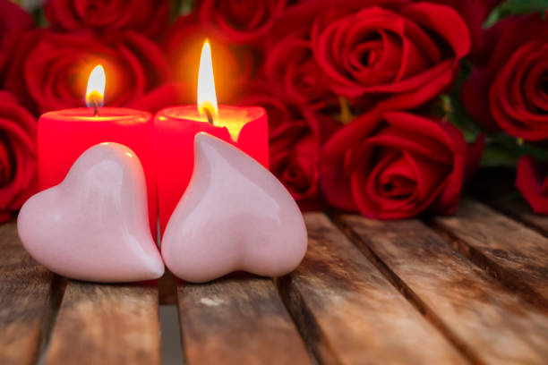 istock Two burning candles with fresh roses 905571758