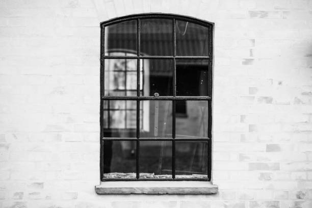 Old fashioned window with transparent glass in black and white on a brickwall in monochrome colors
