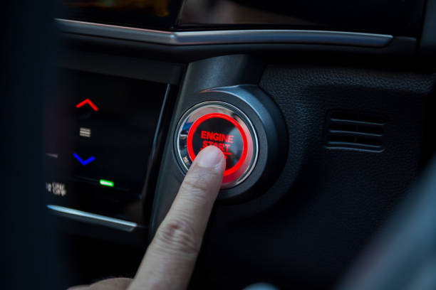 Fingers pressing car start button stock photo