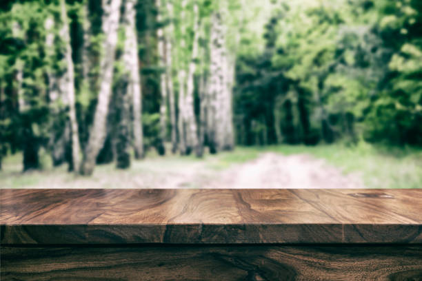 istock Empty top wooden table and floral blurred background 905575660