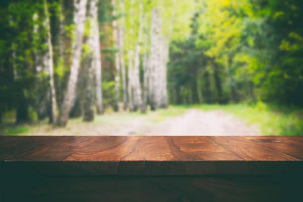 istock Empty top wooden table and floral blurred background 905575702