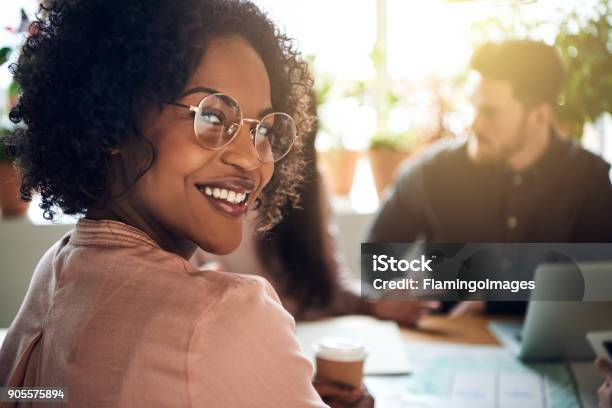 Photo libre de droit de Femme Daffaires Africaine Souriant Lors Dune Réunion De Divisionnaires Dans Un Bureau banque d'images et plus d'images libres de droit de Travail d'équipe