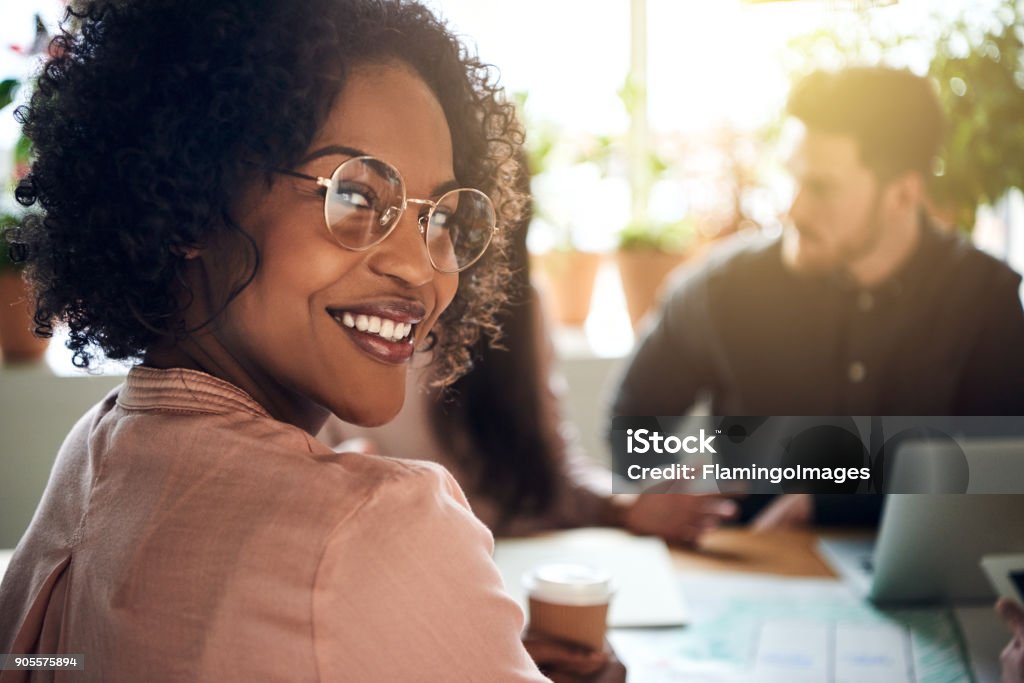 Empresária africana sorrindo durante uma reunião de boardoom em um escritório - Foto de stock de Trabalho de Equipe royalty-free