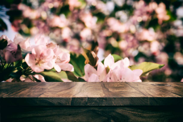 istock Empty top wooden table and floral blurred background 905575916