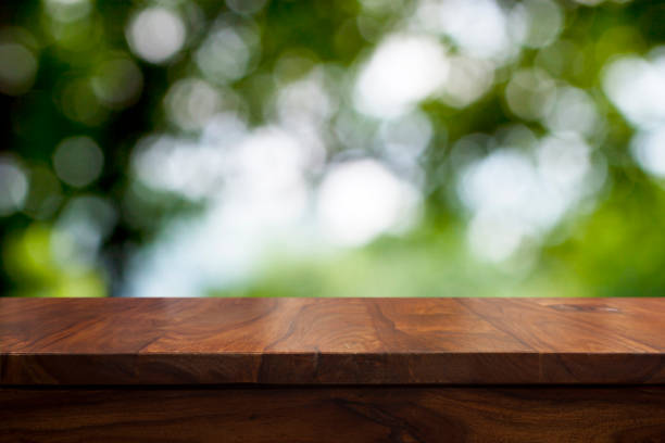 istock Empty top wooden table and floral blurred background 905576010