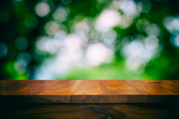 istock Empty top wooden table and floral blurred background 905576062
