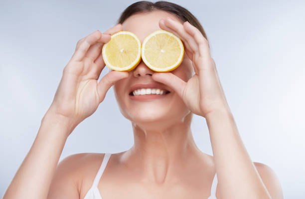 istock Woman closing eyes with two yellow lemons 905580210