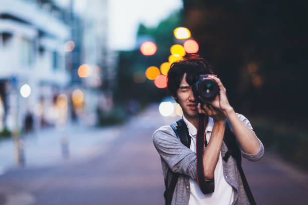 hombre tomando fotos en la noche - japón fotos fotografías e imágenes de stock