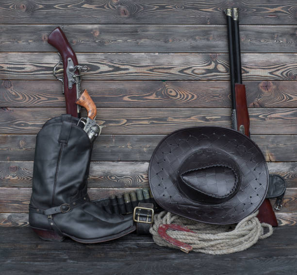 istock Cowboy boots and weapons in the barn 905584142