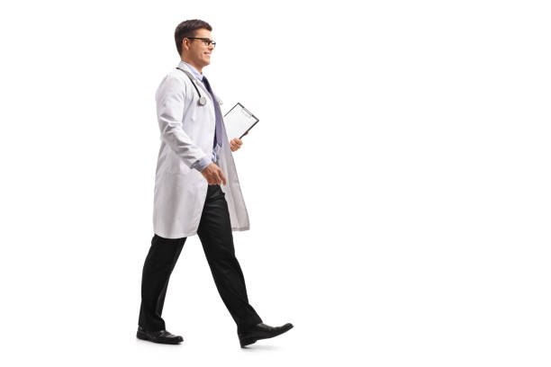 Doctor with a clipboard walking Full length profile shot of a doctor with a clipboard walking isolated on white background full body isolated stock pictures, royalty-free photos & images