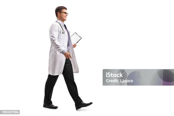 Doctor With A Clipboard Walking Stock Photo - Download Image Now - Doctor, Walking, Full Length