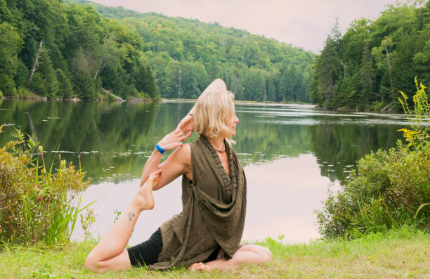 istock Blond woman practicing yoga by a lake 905587494
