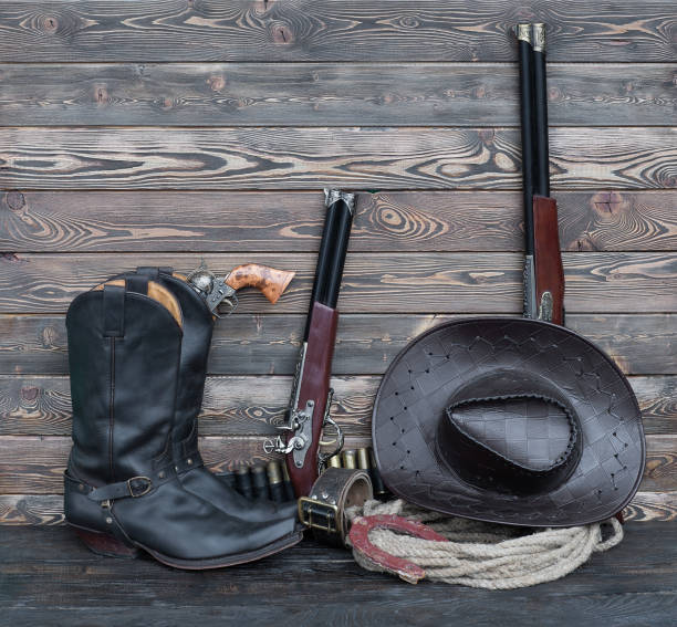 istock Cowboy boots and weapons in the barn 905587920