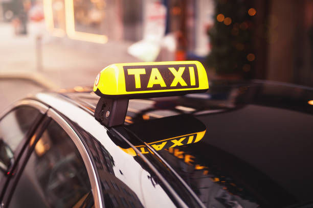 táxi amarelo sinal de telhado de carro à noite. carro de táxi na rua à noite - táxi - fotografias e filmes do acervo