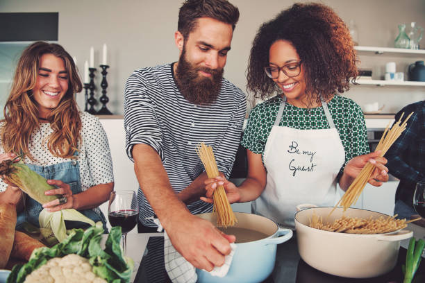 tres amigos cocinar espaguetis - domestic kitchen people fun lifestyles fotografías e imágenes de stock