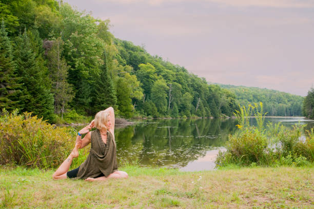 istock Blond woman practicing yoga by a lake 905588290