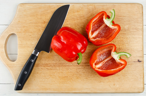 Whole and sliced bell pepper on cutting board. Raw ingredients before cooking