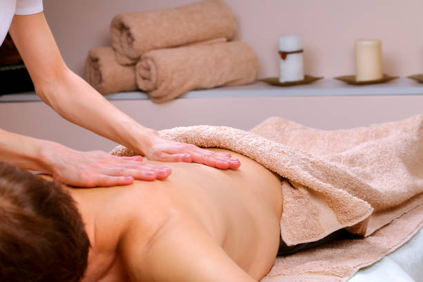 massage thérapeute massages épaules et le dos d’un homme - lastone therapy spa treatment massaging massage therapist photos et images de collection