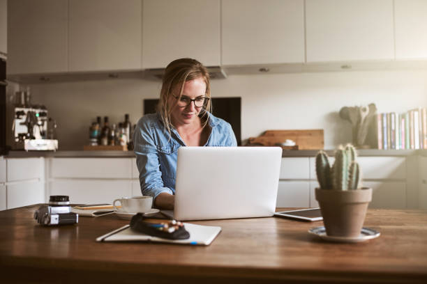 istock Young woman working online in her kitchen with a laptop 905594978