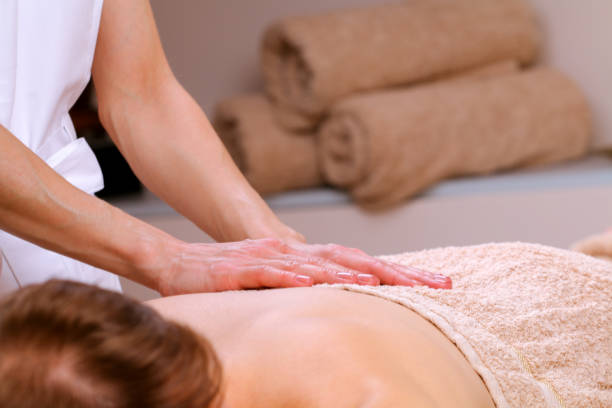 massage therapeuten massieren schultern und rücken eines mannes - lastone therapy men spa treatment male stock-fotos und bilder