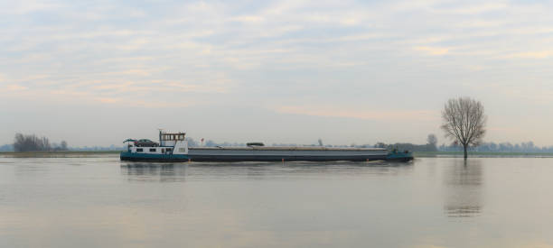 istock Barge freight ship on the river IJssel during a winter morning 905595332