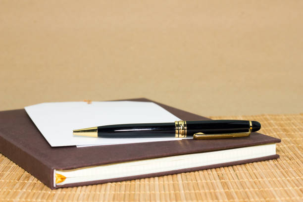istock note paper and black pen on brown background 905603250
