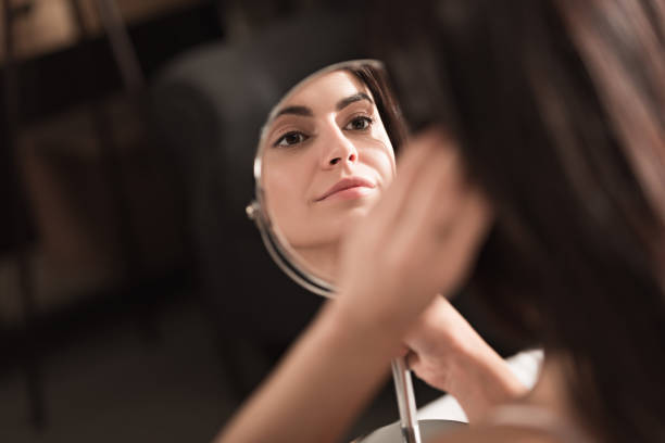 istock woman looking into the mirror 905604090